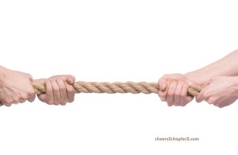 Two people in a power struggle tug of war with rope