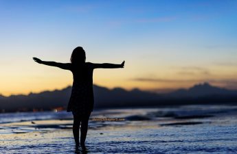 woman standing by ocean deciding to take a risk and feel fierce