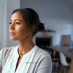 Pensive woman looking out window for simple ways to beat stress and boost happiness