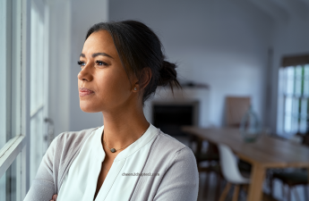 Pensive woman looking out window for simple ways to beat stress and boost happiness